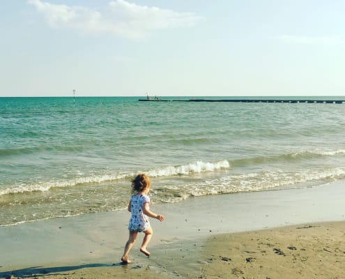 spiaggia grado cielo sabbia bambina corre