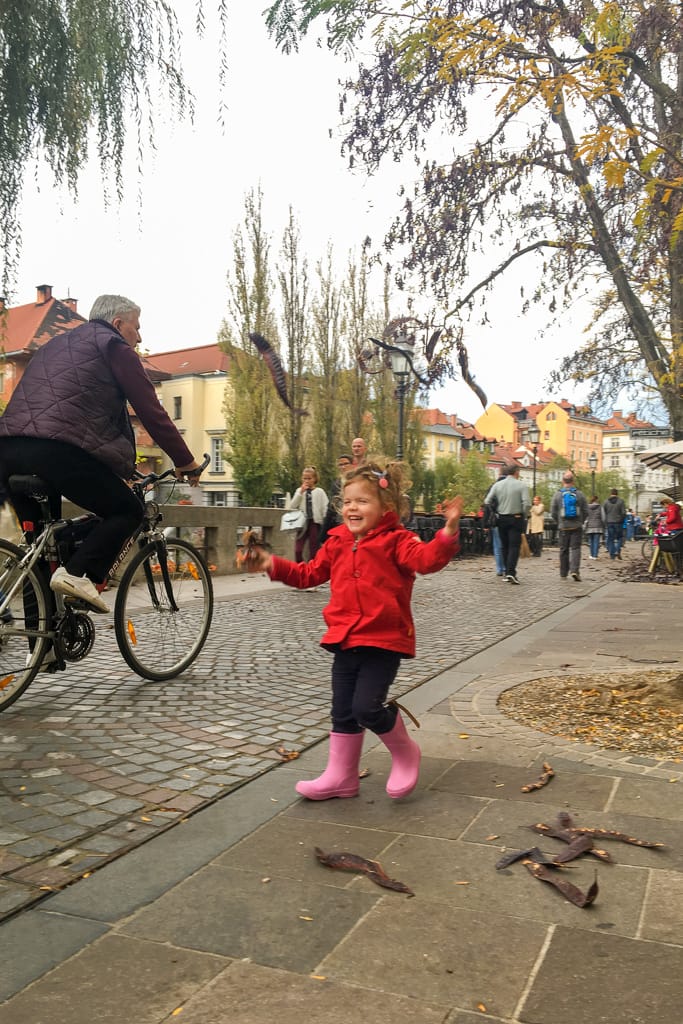lubiana autunno foglie palazzo bambina foglie bicicletta