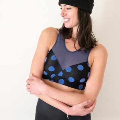 farah activewear di lusso sostenibile made in italy. donna indossa leggings neri per yoga e elegante top nero a pois blu