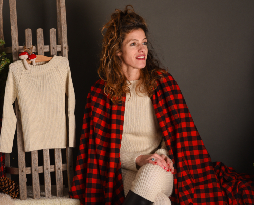 a woman wearing alpaca clothing and choosing beautiful winter outfits for children