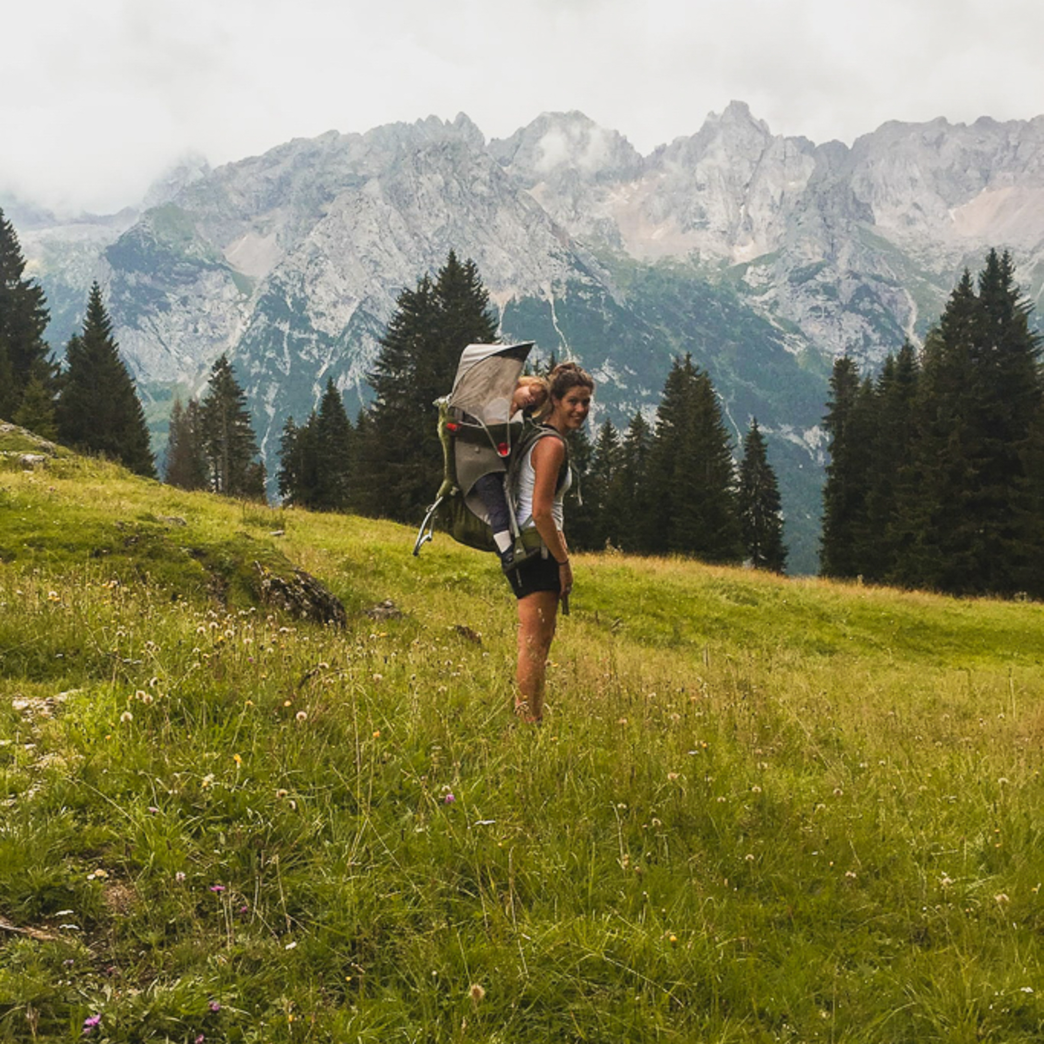 mamma felice con bambina sulle spalle in una camminata sulle dolomiti